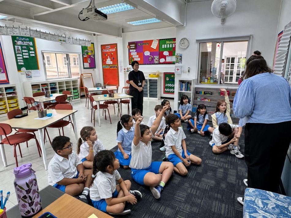 Students raising their hands during a whole-class discussion