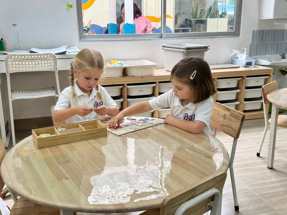 Two students working together on a puzzle at a table