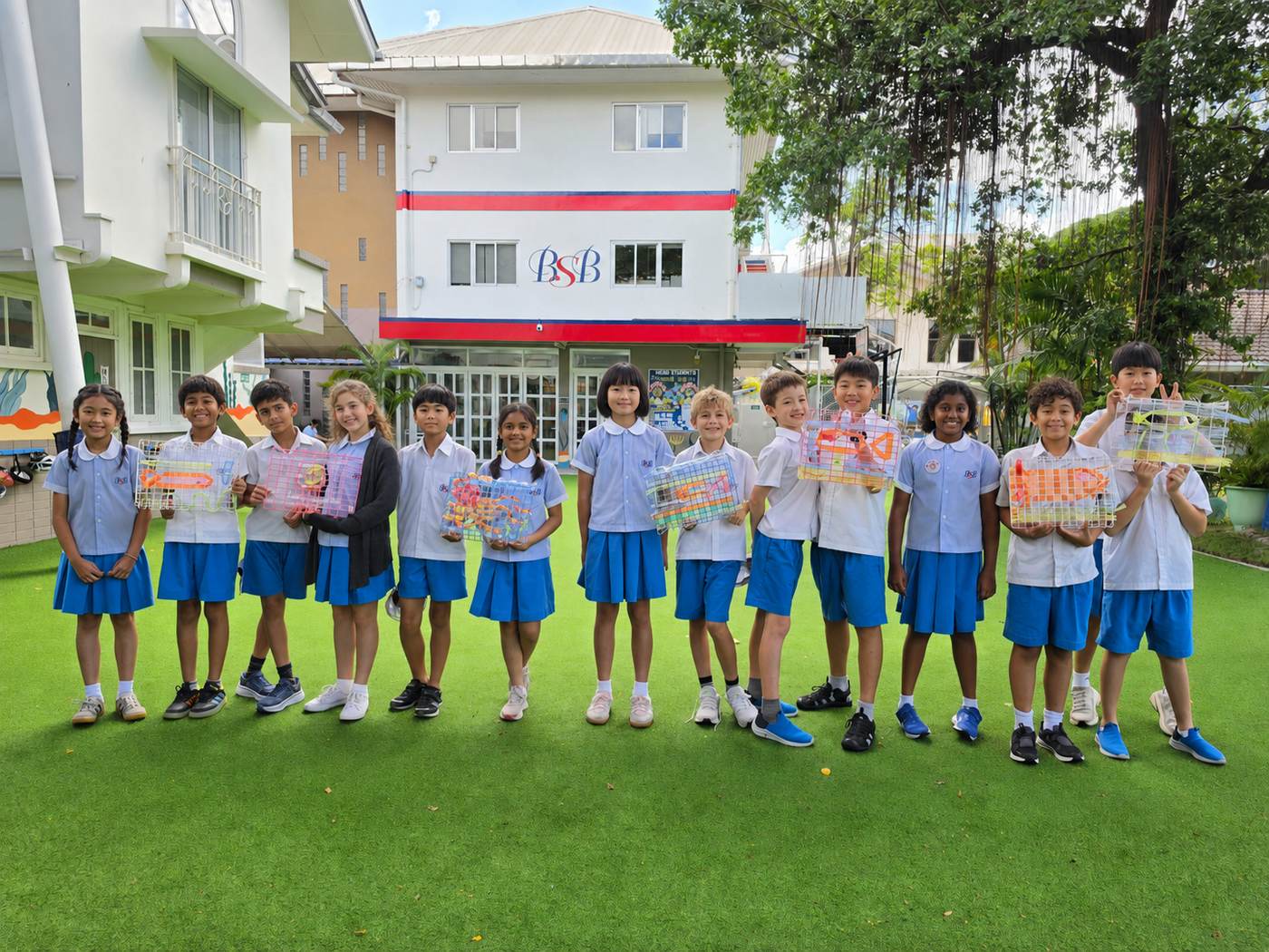 A group of students with their handmade lantern crafts outside the school