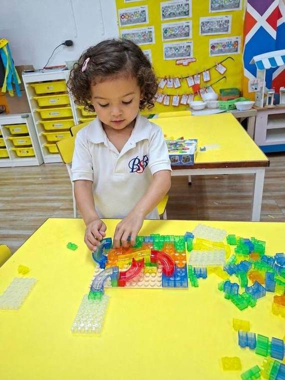 A student building with connector blocks during Building Club