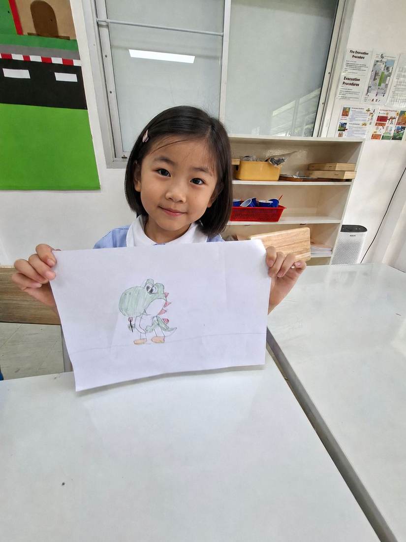 A student showing off a finished cartoon drawing during Cartoon Drawing Club
