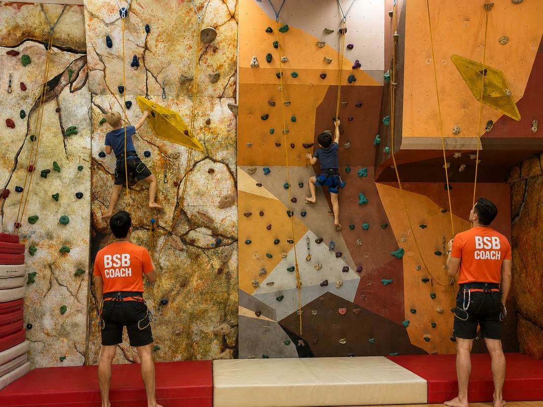 A student reaching for the next hold during Climbing Club