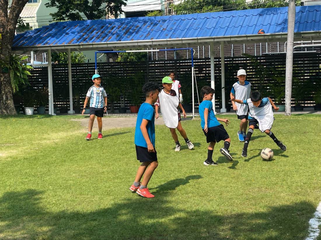 Students playing football together during Football Club