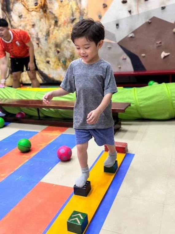A student balancing across stepping blocks during Junior Gym