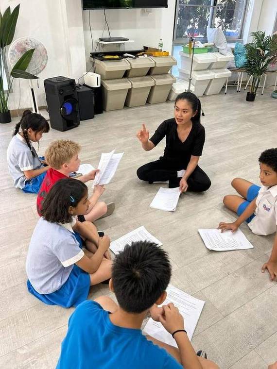 Students reading through their scripts with their teacher during Musical Theatre
