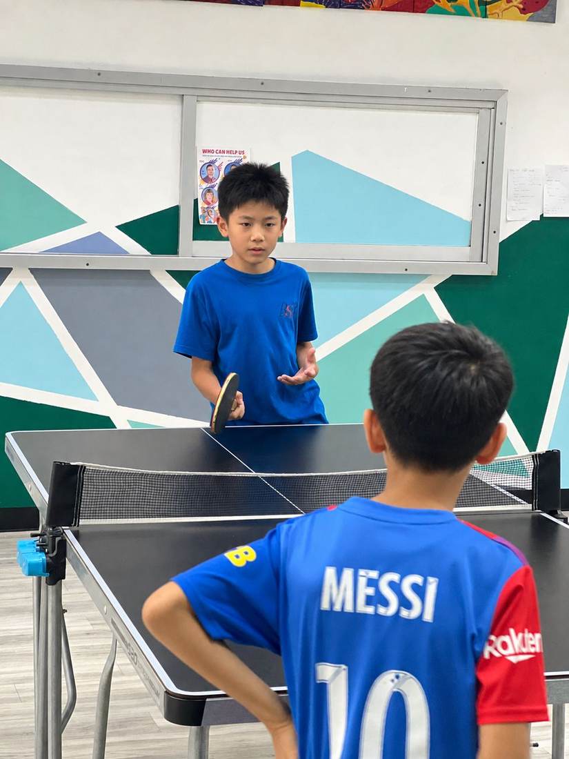A student practising a table tennis serve during Table Tennis Club