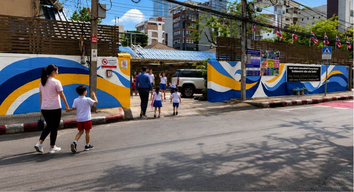 Families arriving at the school entrance gate on the street