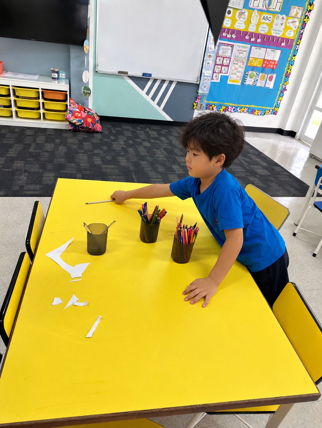 A student organising trays and papers in the classroom