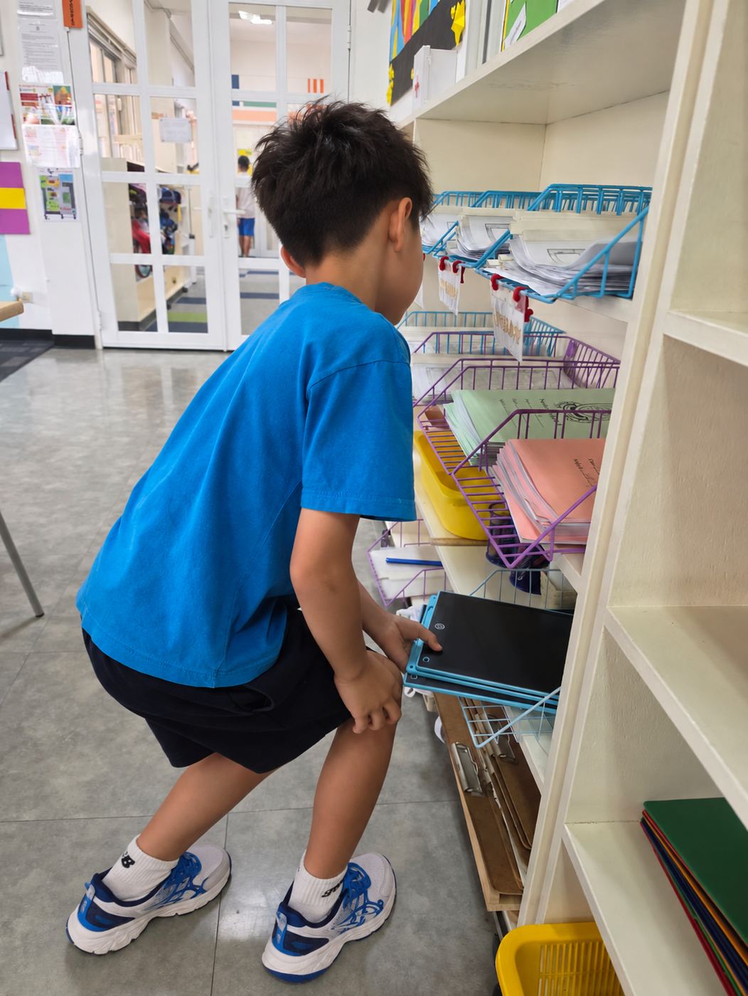 A student putting away classroom equipment