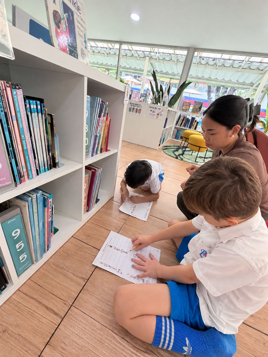 Students working through an English language worksheet with their teacher