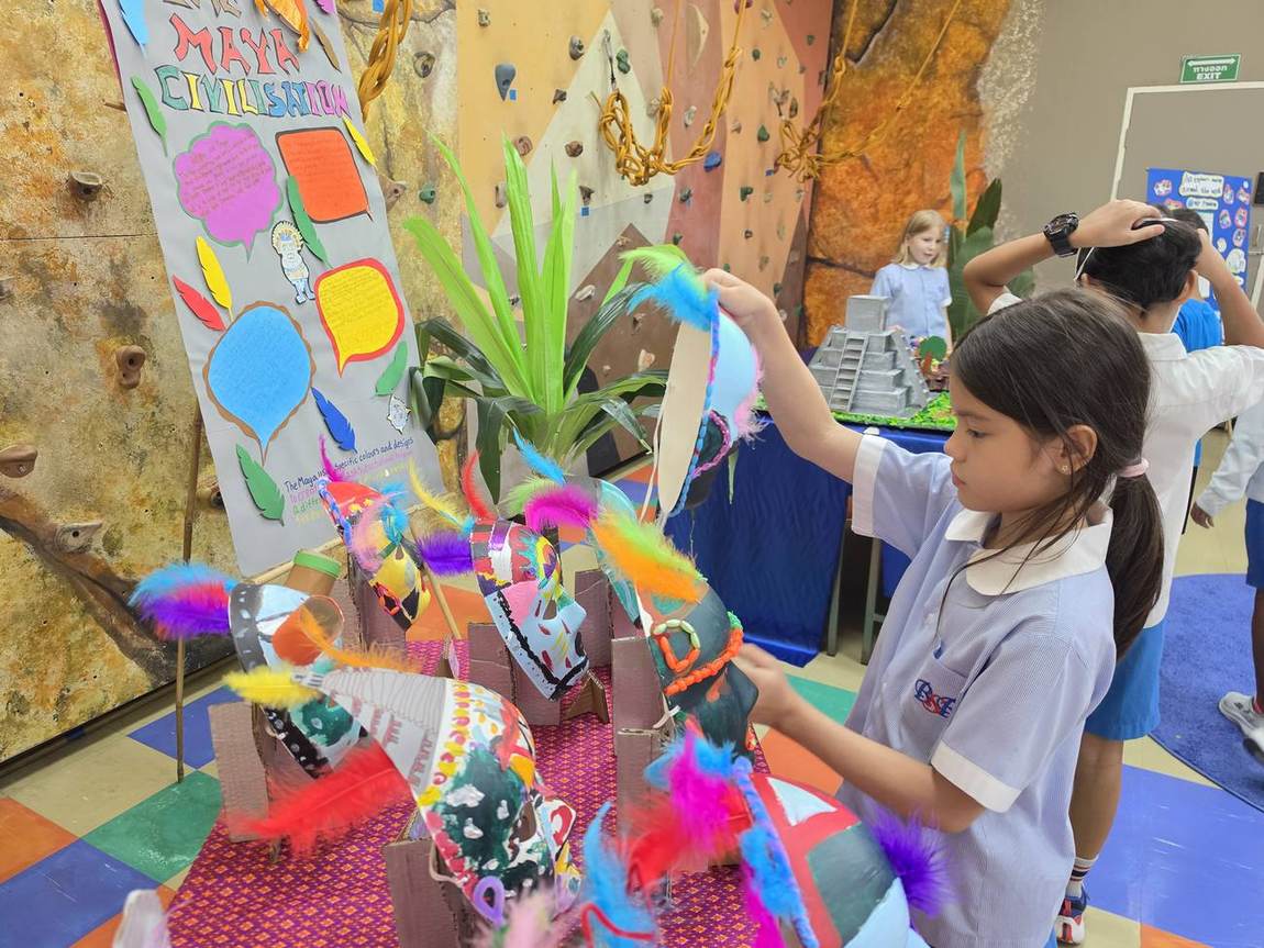 A student painting a large collaborative mural at the Art Gala