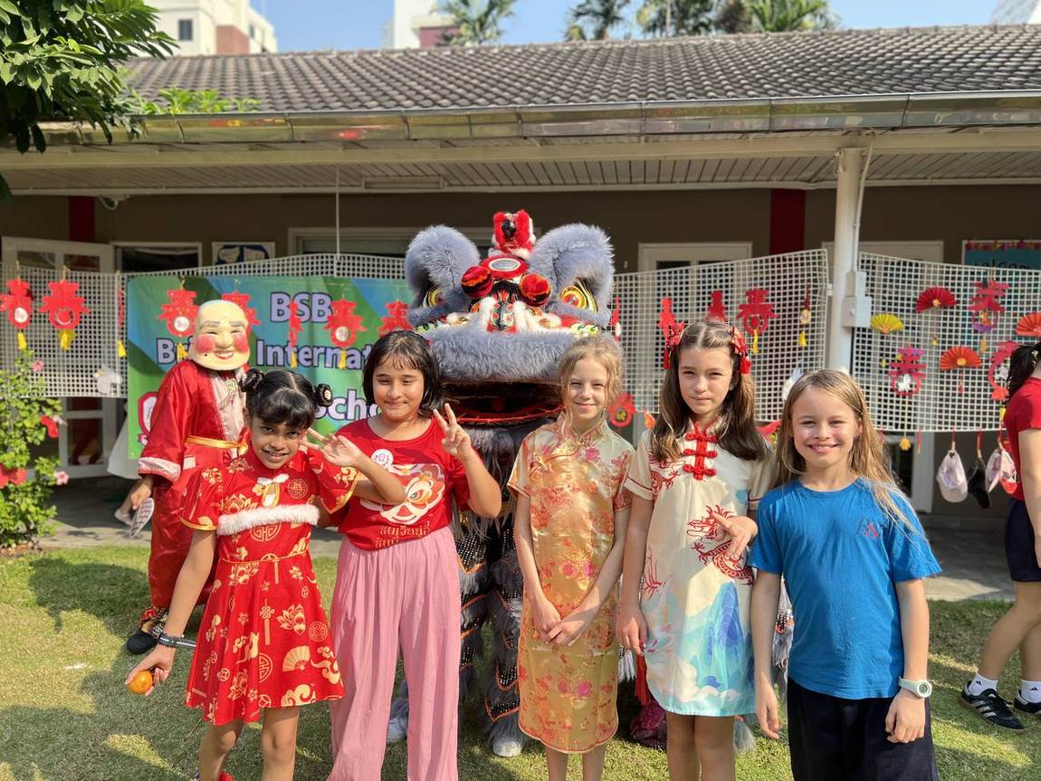 Students in traditional Chinese New Year outfits with lanterns