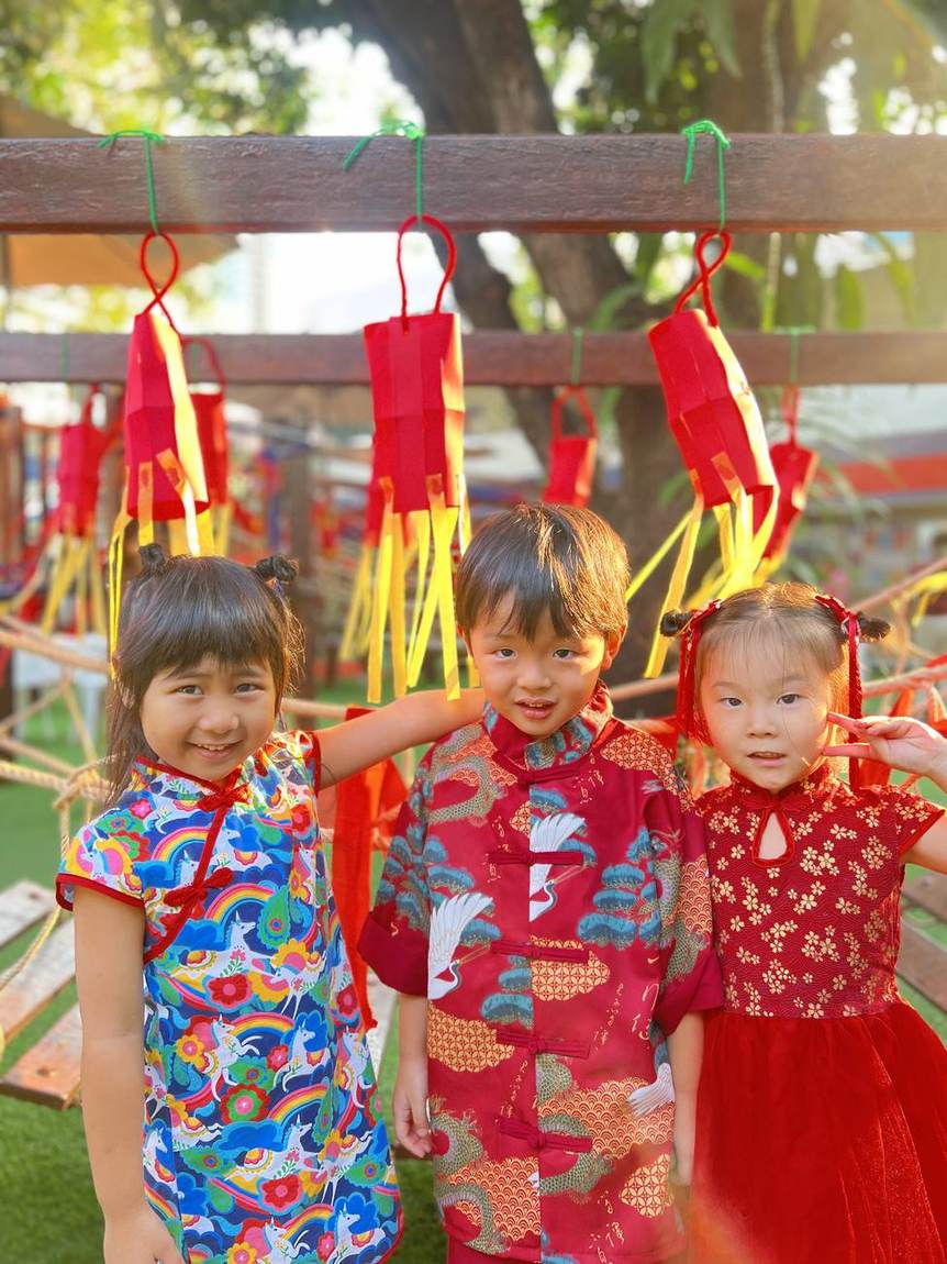 Two students smiling in Chinese New Year outfits