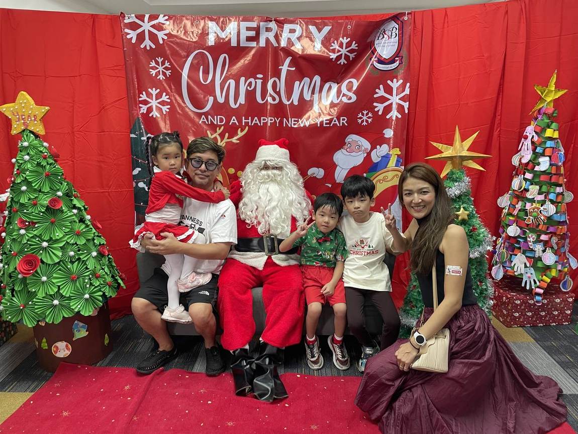 Two students posing in a festive photo frame at the Christmas Show