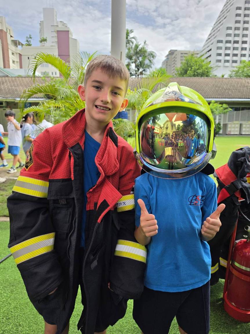 A student posing with a firefighter at the Fireman Show