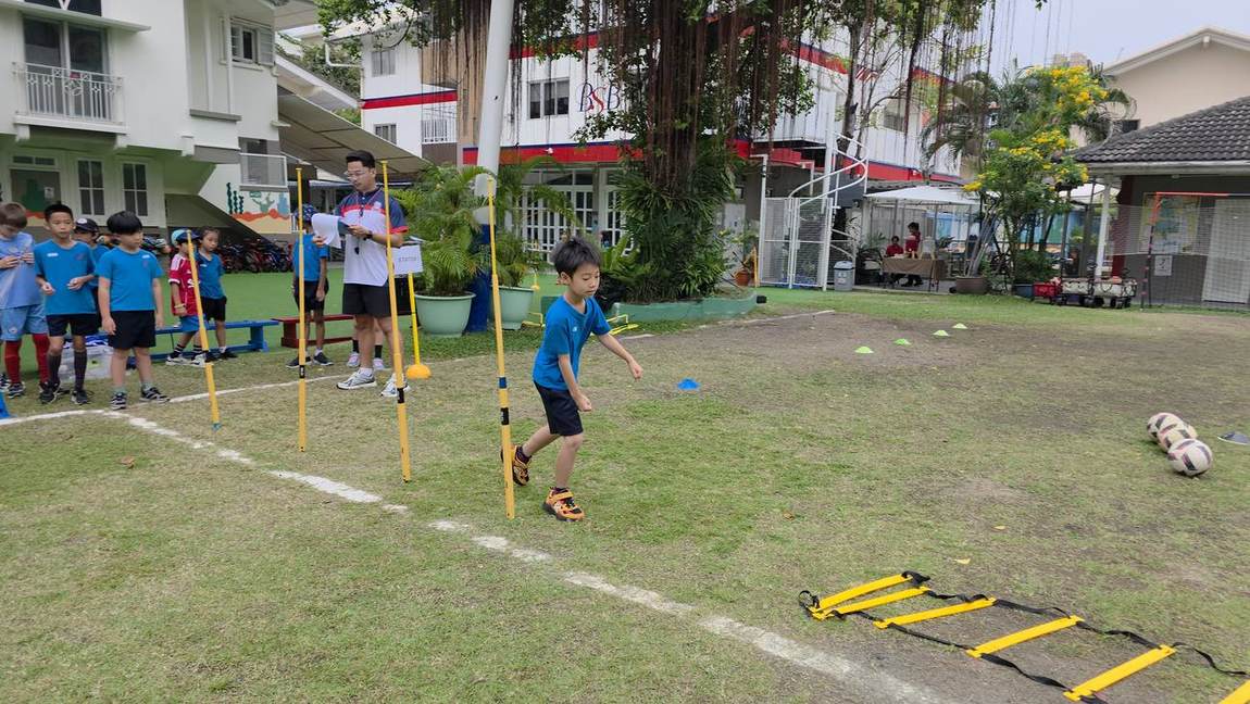 Students practising dribbling drills at football try-outs
