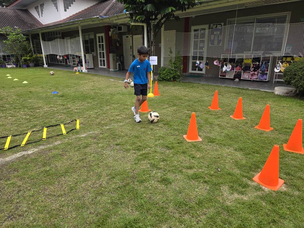 A coach guiding students through football try-outs