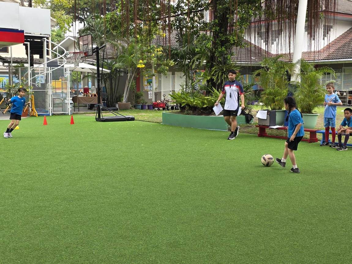 Students and coach in action at football try-outs