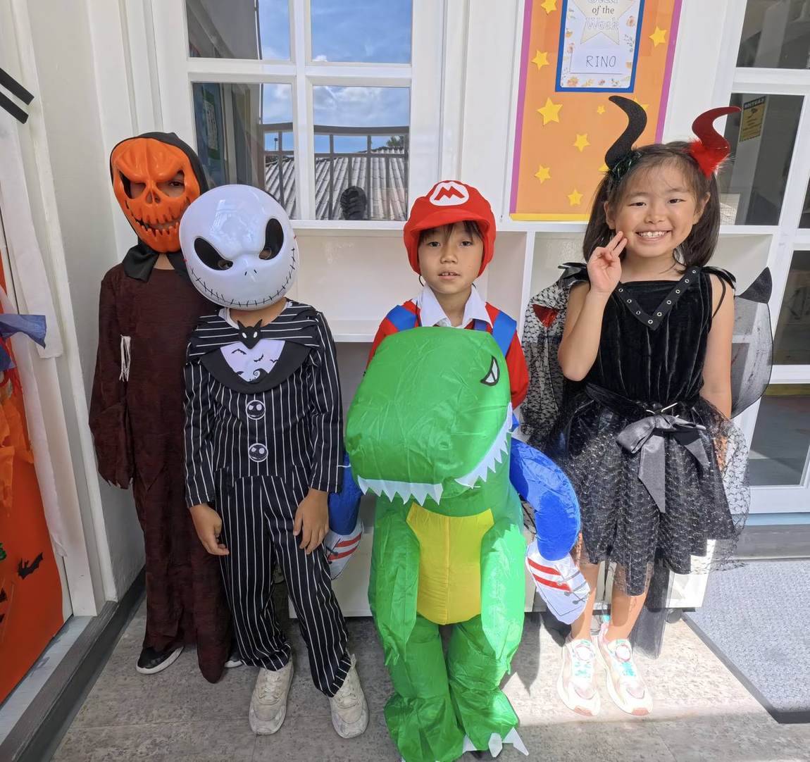 Students in Halloween costumes posing indoors