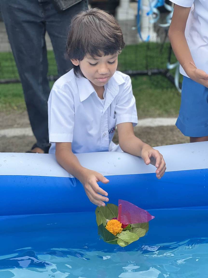 Students releasing krathongs into the water for Loy Krathong Day