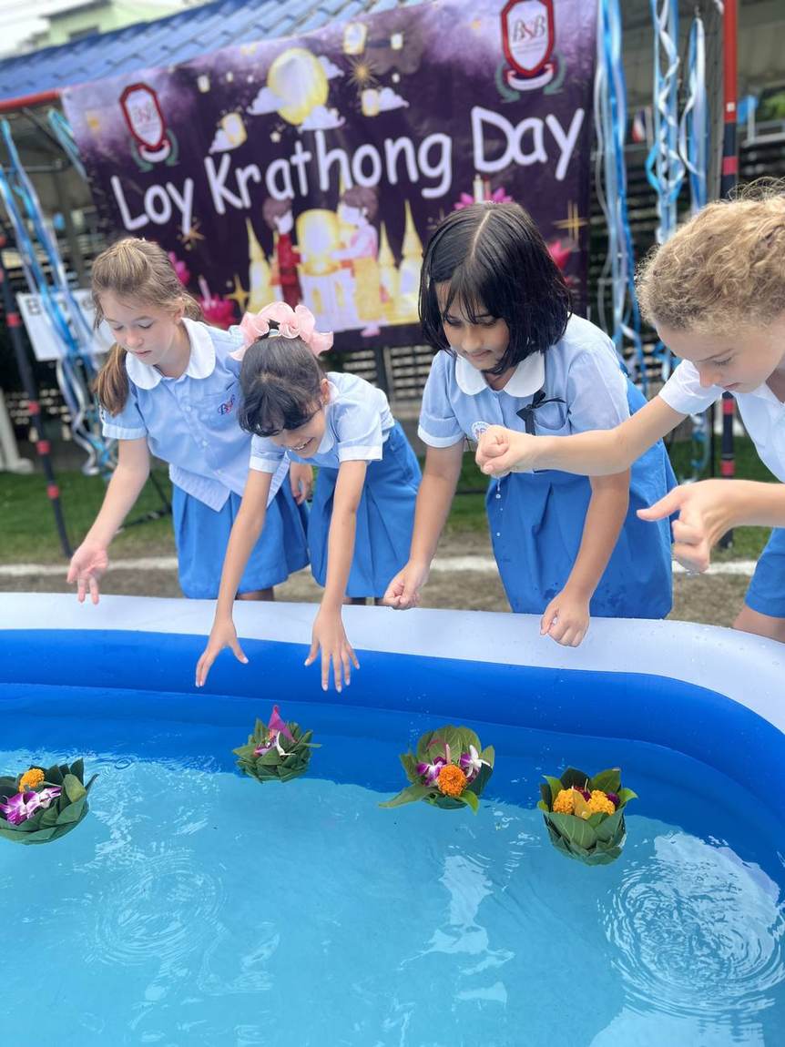 Two students holding flower krathongs