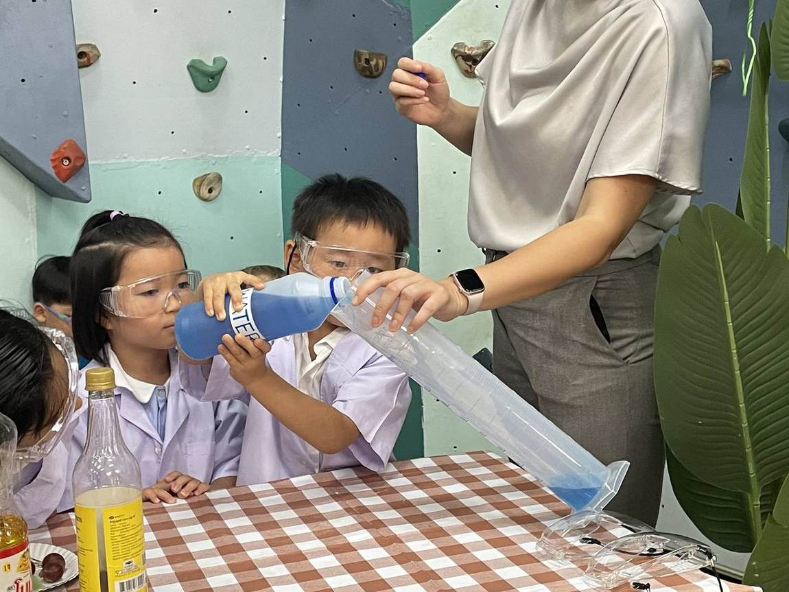 Students pouring liquid during a Science Week experiment