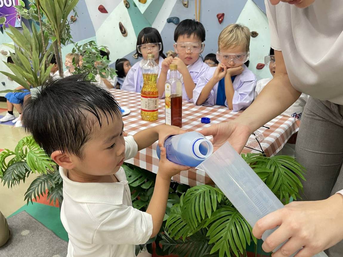A student pouring liquid into a bottle during Science Week