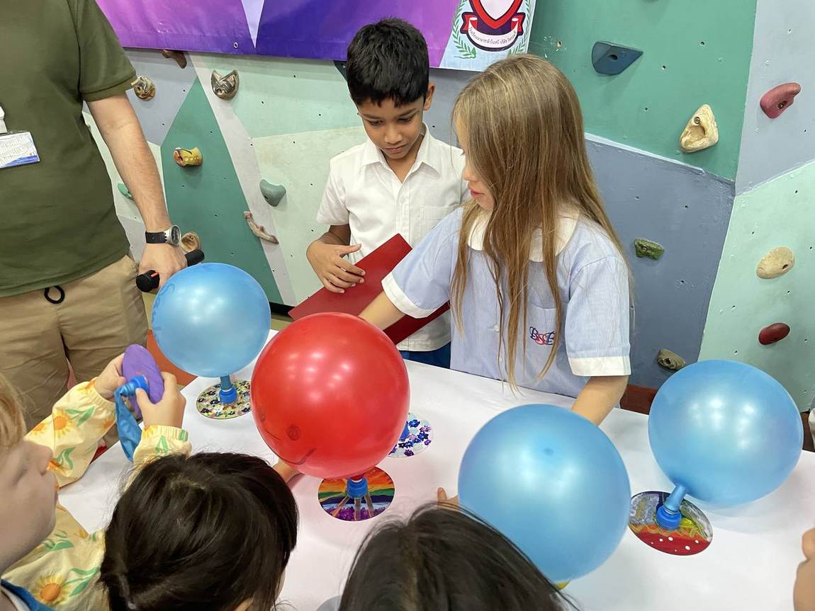 Students exploring a static electricity balloon experiment during Science Week