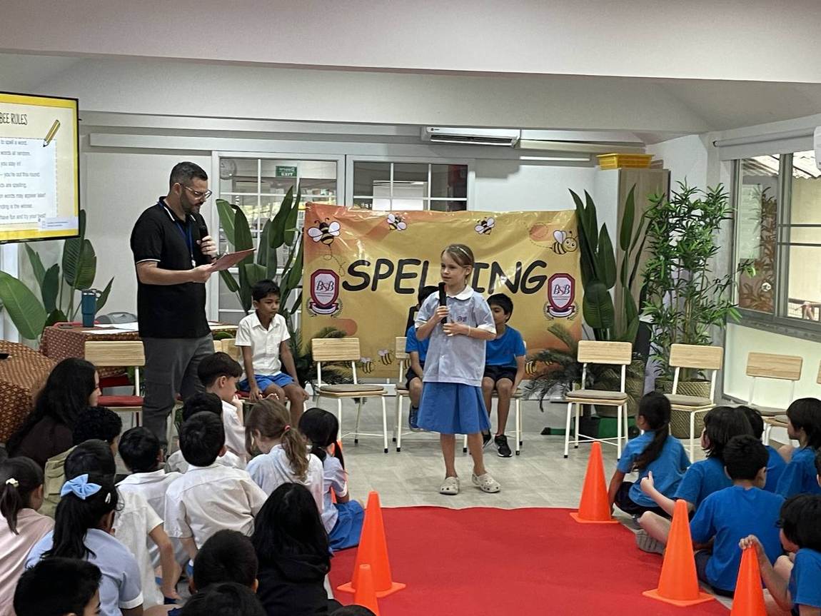 Students seated on stage during the Spelling Bee competition
