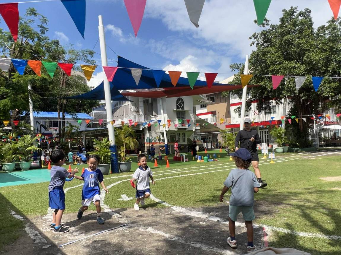 A student running a cone drill race on Sports Day