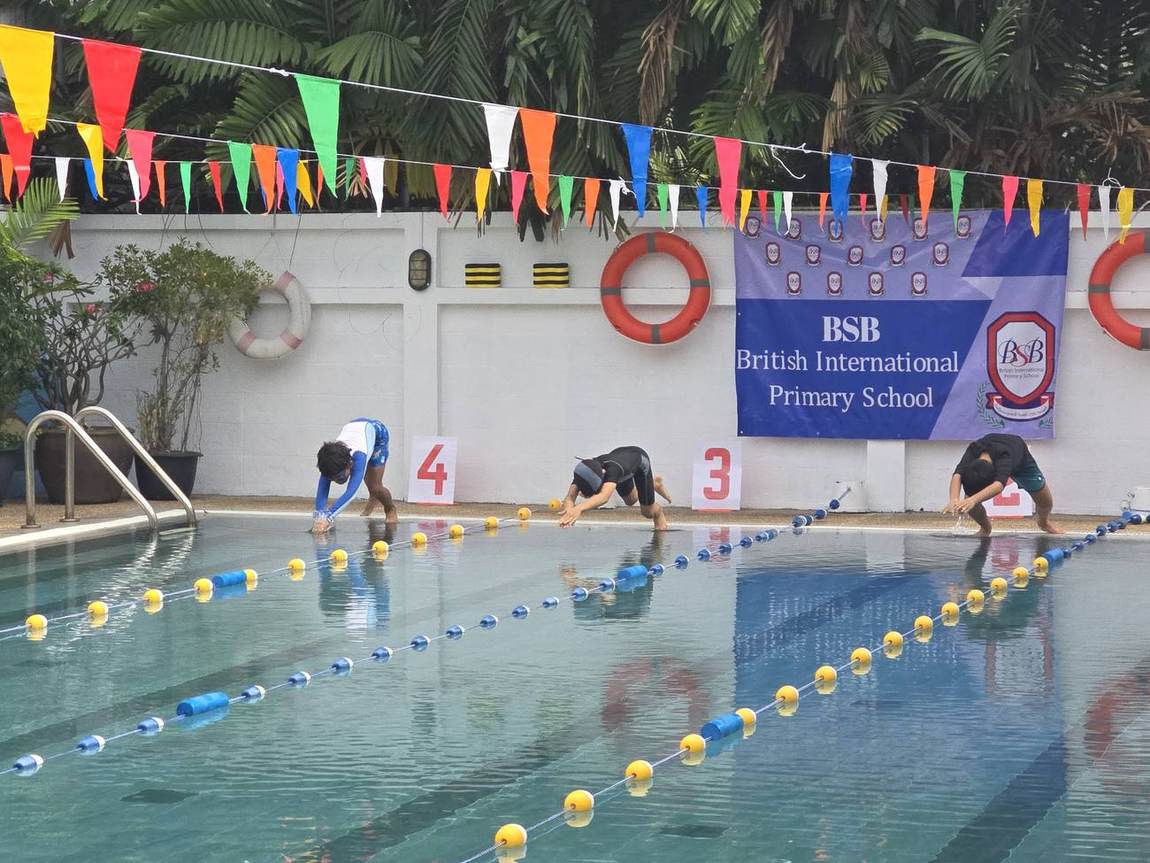 Two students in goggles smiling poolside at the Swimming Competition
