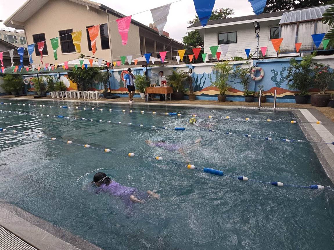 Students smiling at the pool edge during the Swimming Competition