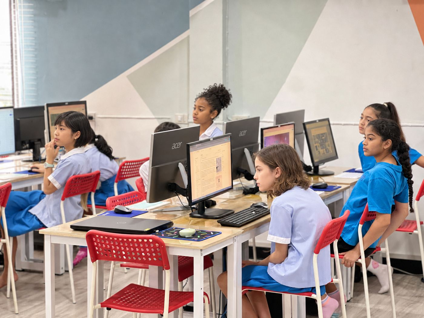 Older students researching and typing together at their workstations
