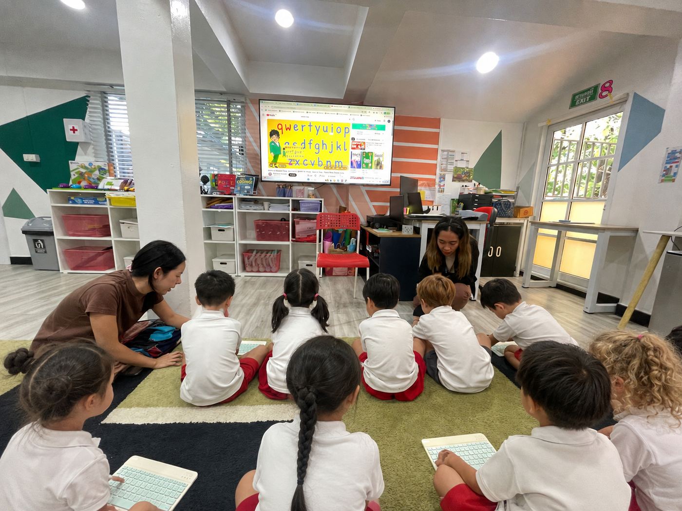 Young students with tablets following a keyboard and typing lesson
