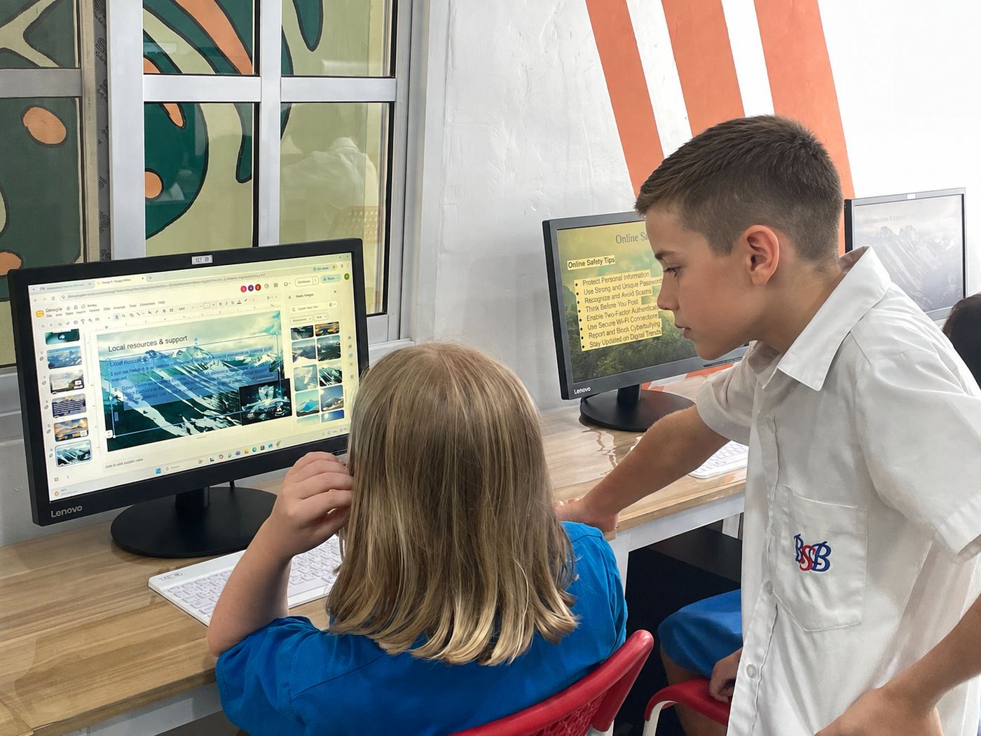 Students collaborating on a slide presentation about online safety