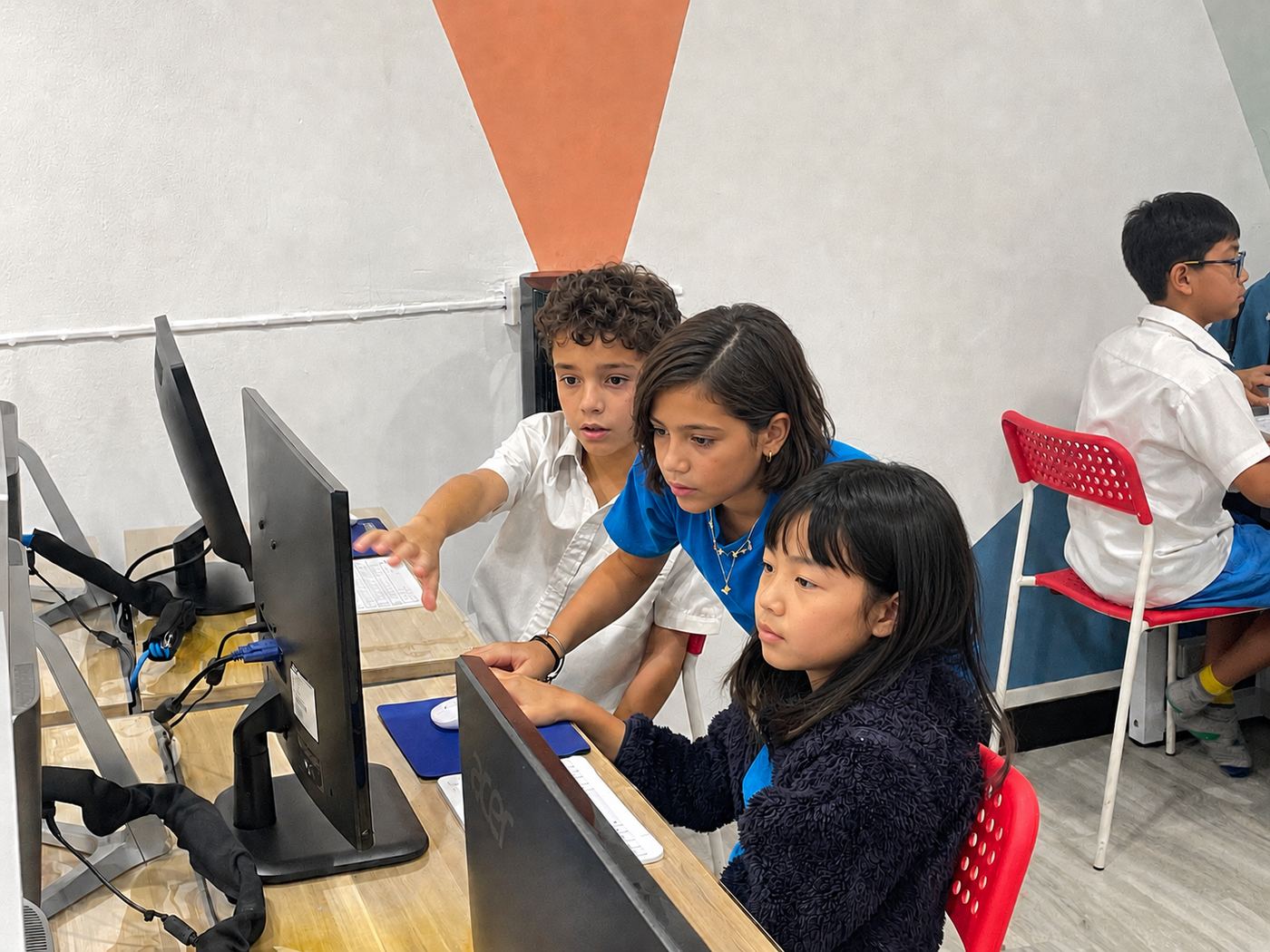 Students working together at computers, helping each other