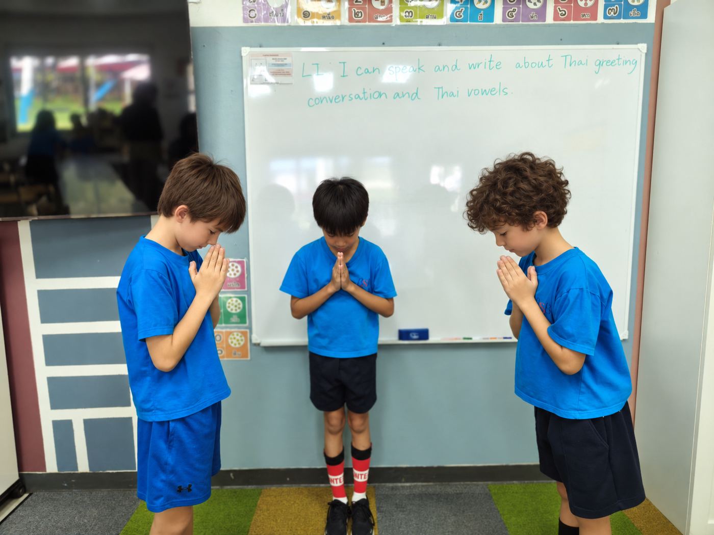 Students greeting their teacher with a wai during a Thai lesson