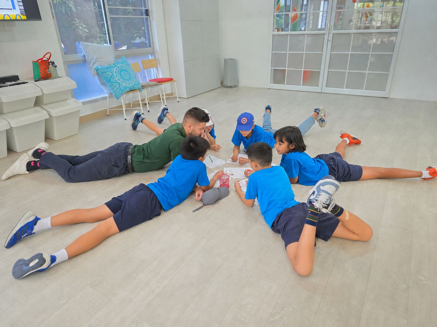 Students and their teacher working together on the floor