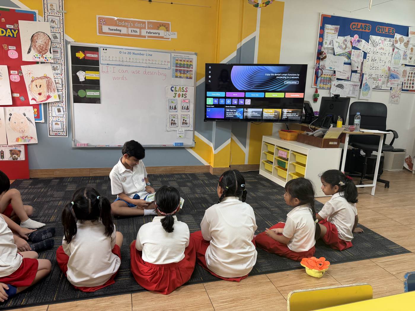 An older student reading aloud to younger classmates