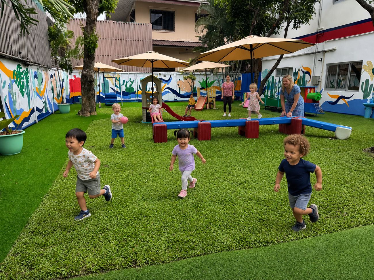 Nursery-age students running together on the playground