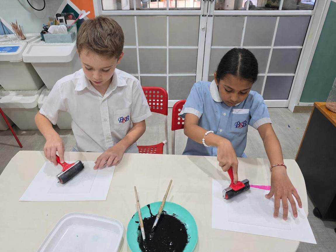 Students rolling ink for a printmaking activity