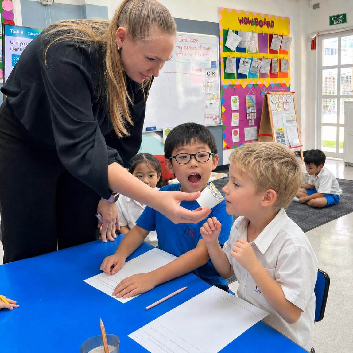 A teacher helping students with a hands-on table activity