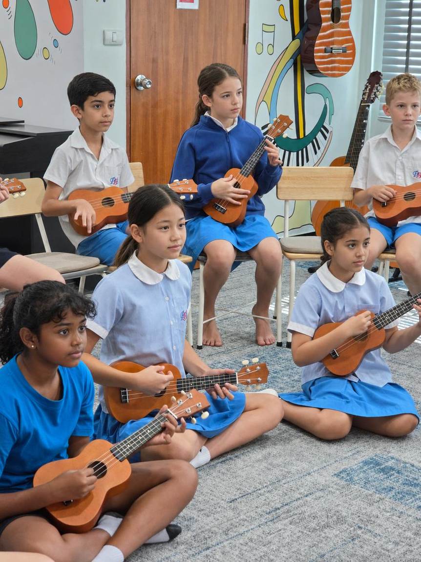 Students playing ukuleles together